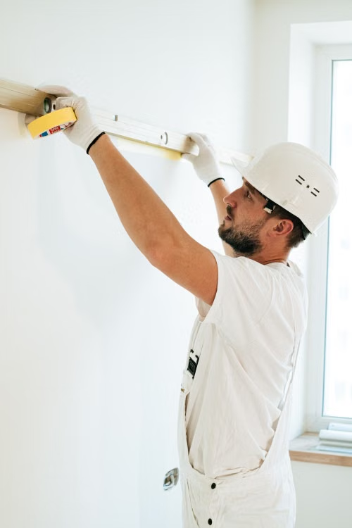 Carpenter leveling crown molding during a crown molding installation in a Springfield, MO home